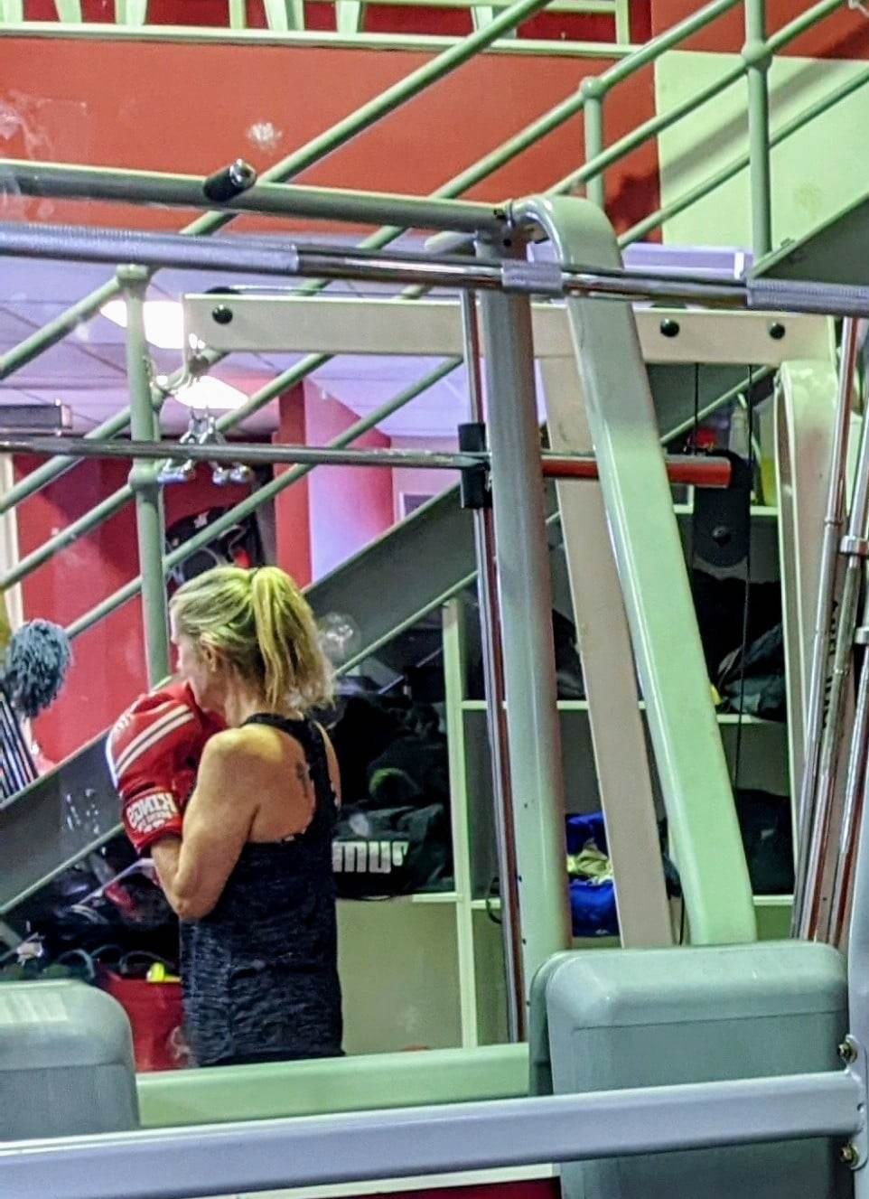 woman at boxing gym reflected in the mirror