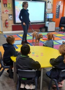 woman in a classroom with a therapy dog
